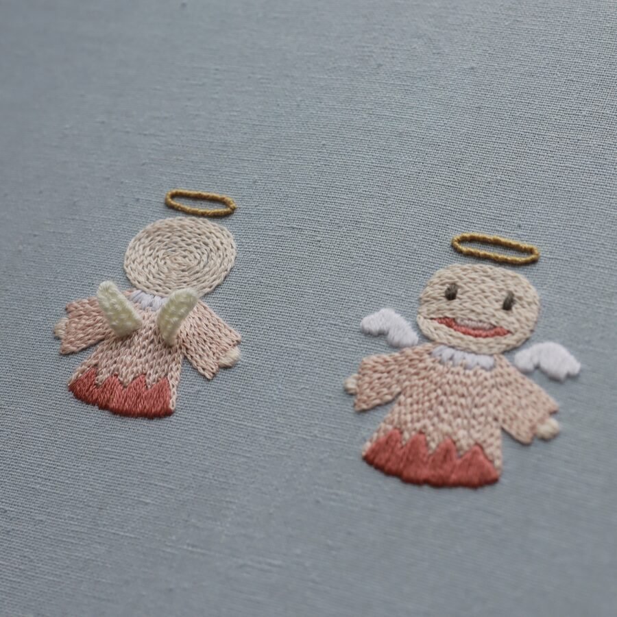 Detail shot of two embroidered angels from "Doraemon's Gadgets," one facing forward and the other turned away.