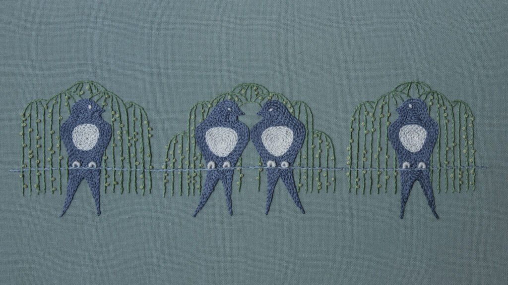 The complete 'Waiting for Spring' embroidery by lissyluo, featuring four stylized blue-gray birds perched on a line beneath weeping willow branches on sage green fabric.