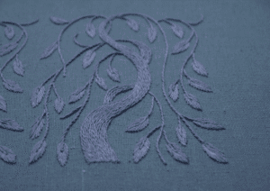 An angled view of a single hand-stitched weeping willow, showcasing the intricate threadwork and serene monochromatic color palette.