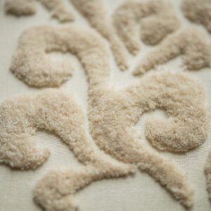  An angled detail shot focusing on the swirling cloud pattern, created with a raised, beige tufted stitch for a soft, 3D effect.