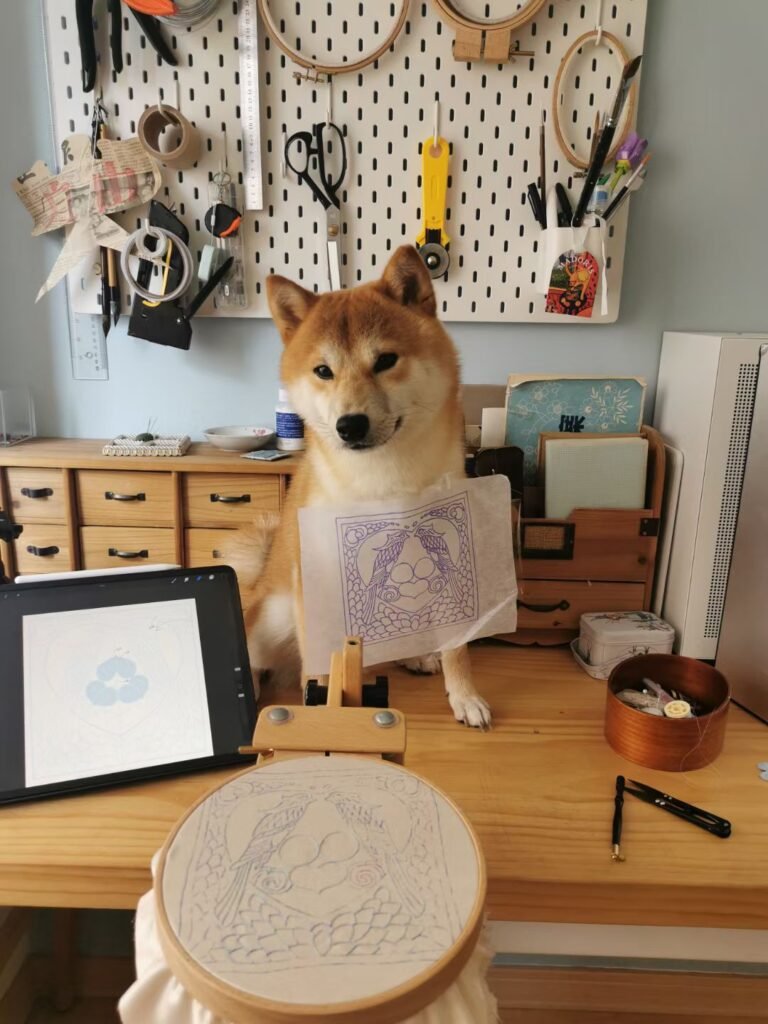 hand embroidery artist lissyluo's shiba aigo is standing on the table.